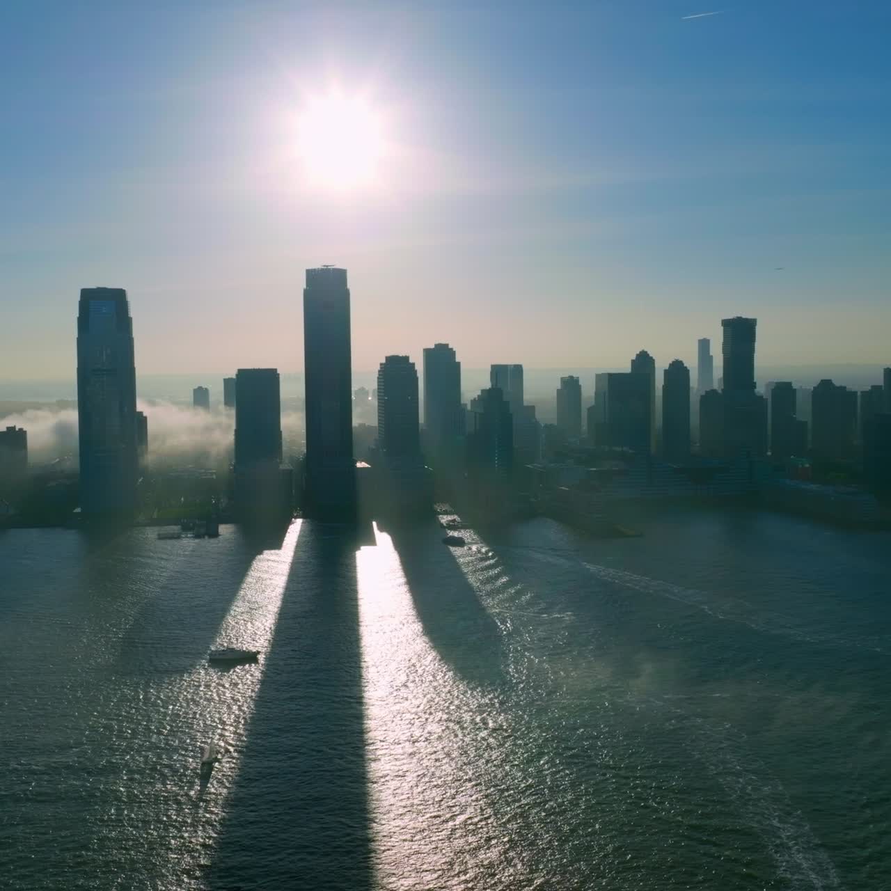 Manhattan Island silhouette in the sunlight coming from behind. Thick fog coming from the river to the city area