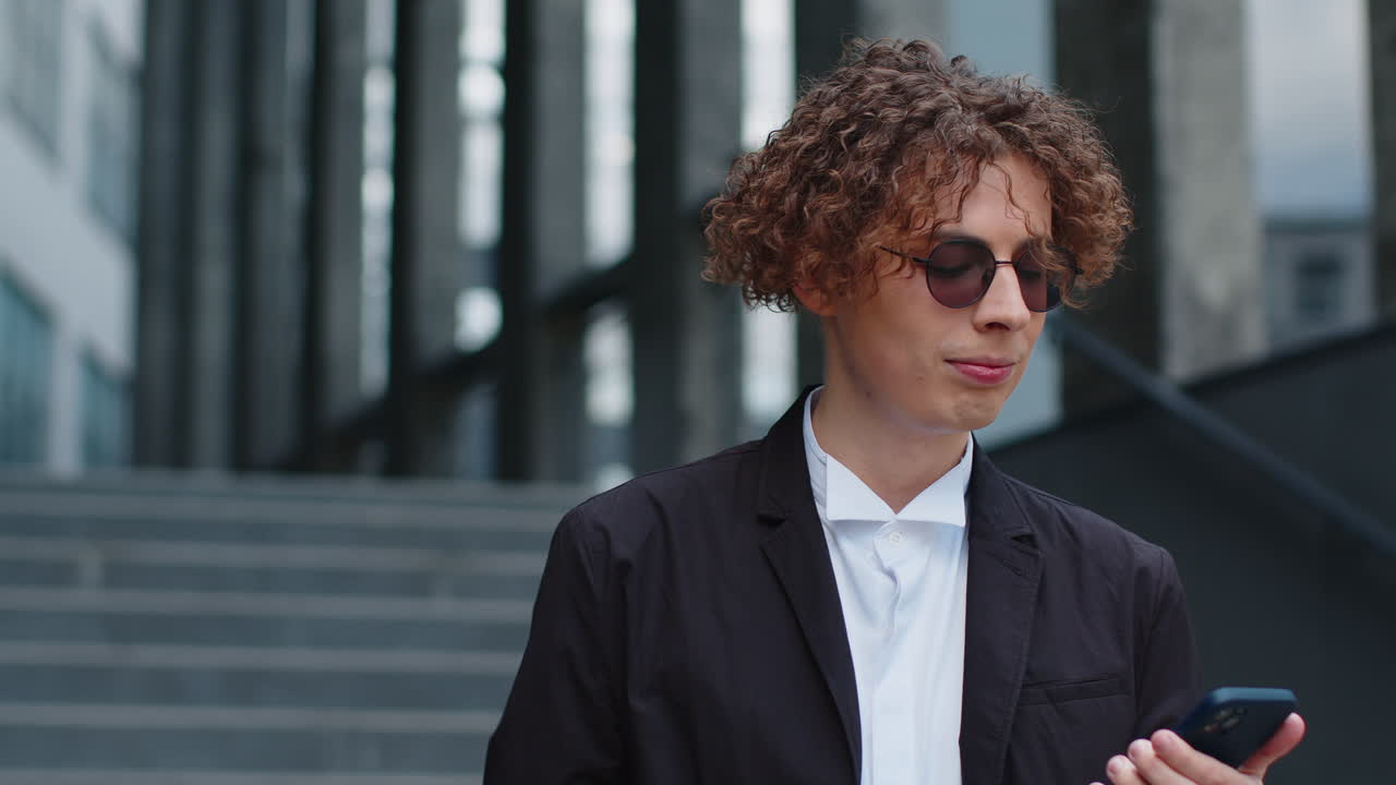 행복 한 사업가 는 스마트폰 을 사용 하고 문자 를 입력 하고 이메일 메시지 에 대답 하고 채팅 하고 카메라 를 보고 있다