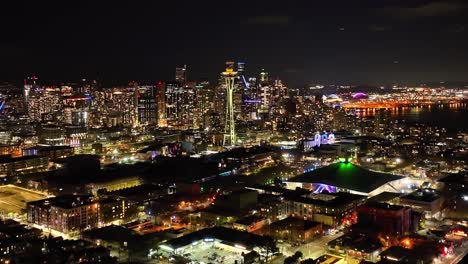 Filmische-Luftaufnahme-Der-Skyline-Von-Seattle,-Die-Sich-Nachts-über-Den-Lichtern-Der-Stadt-Erhebt