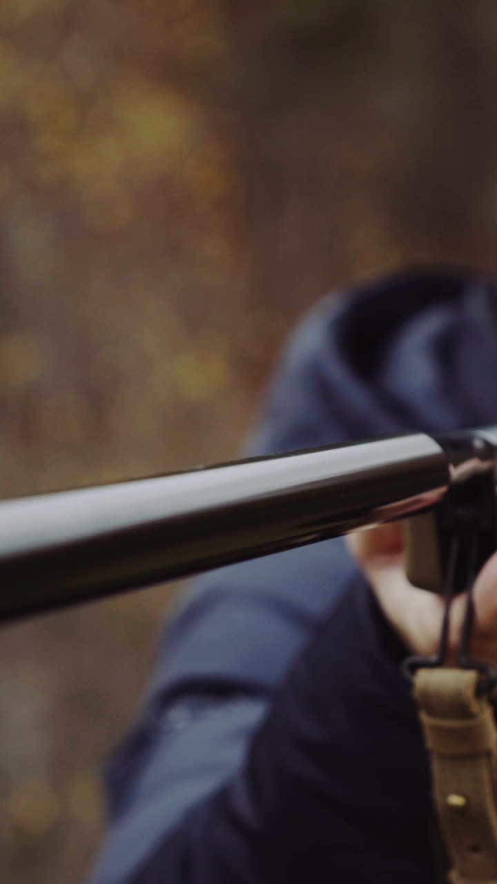 Man shooting gun in forest. Close up of male hunter in the forest aiming and shooting with hunting rifle
