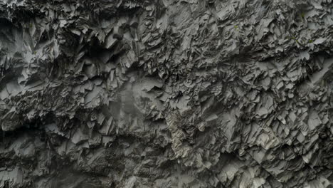 rocky wall with unique hexagonal pattern in a wet cave in iceland