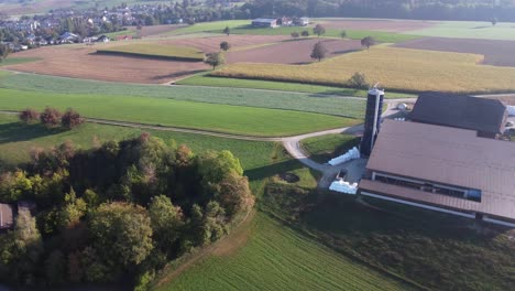 aerial view of small farm house surrounded by fields in switzerland countryside