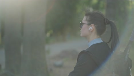 young woman with tennis racket in park