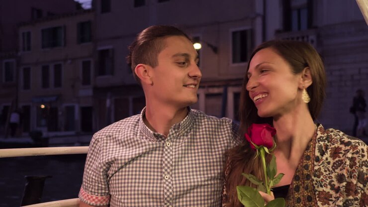 una pareja en un viaje romántico en góndola en venecia por la noche.