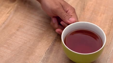 una mano trae la taza de café