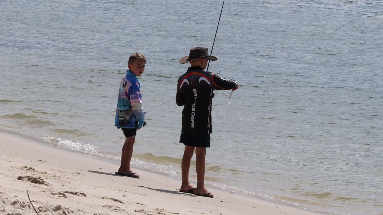 두 아이가 모래 해변에서 함께 시를 하고 있다