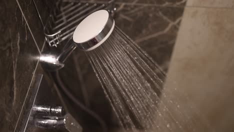water spraying from a modern shower head in a bathroom