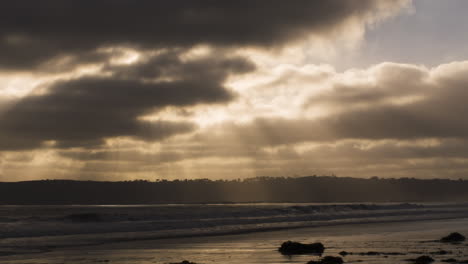 waves break in slow motion on coronado, california, beach at sunset as seagull flies through frame