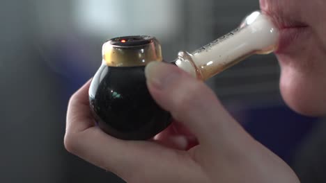 Woman-Smoking-Marijuana-In-A-Pipe---close-up