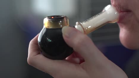 Woman Smoking Marijuana In A Pipe - close up