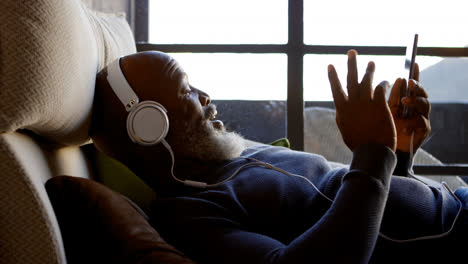 hombre mayor usando teléfono móvil en la sala de estar 4k