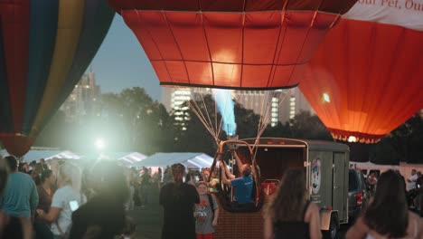 handheld shot of people walking around at hot air balloon glow