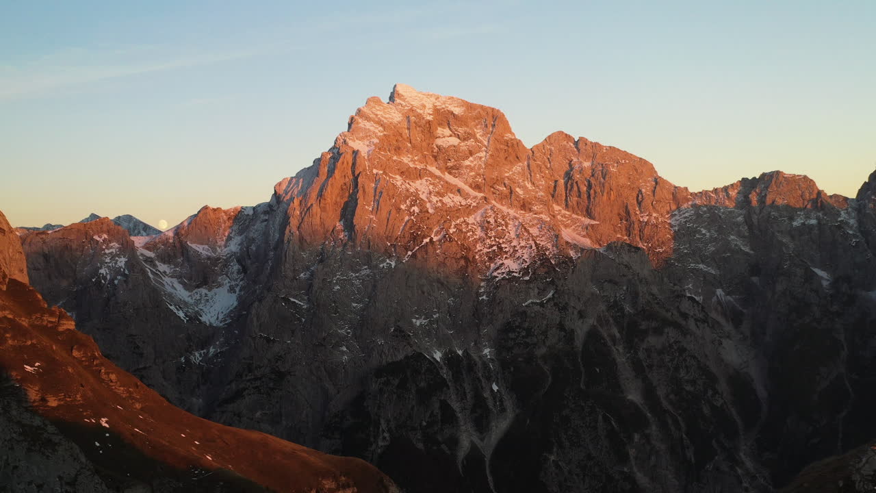 Slovenya'daki Mangart Dağı'nın karla kaplı zirvelerinin sinematik drone çekimiyle ortaya çıkışı.