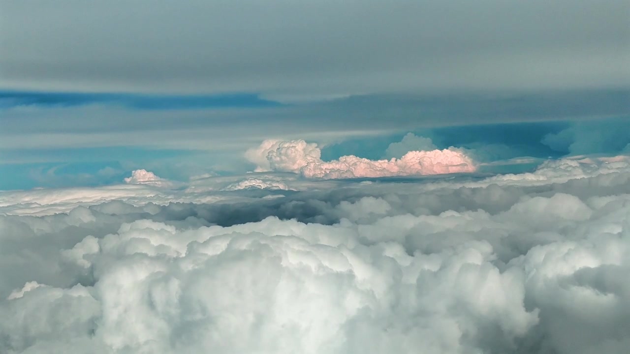 Clouds over a sea of white puffy cumulus formations