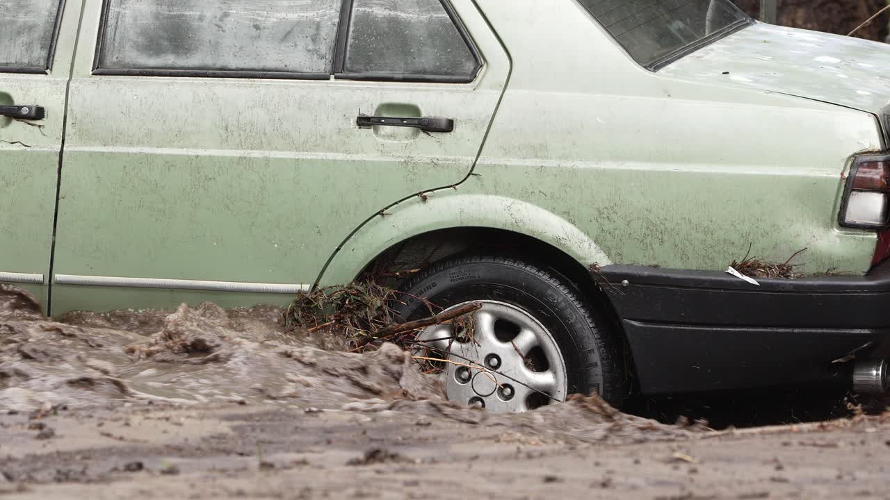 vista de cerca de un automóvil atrapado en la inundación de un río causada por fuertes lluvias