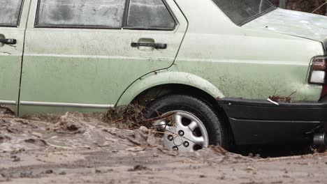 Close-up-view-of-a-car-caught-in-a-river-flood-caused-by-heavy-rains