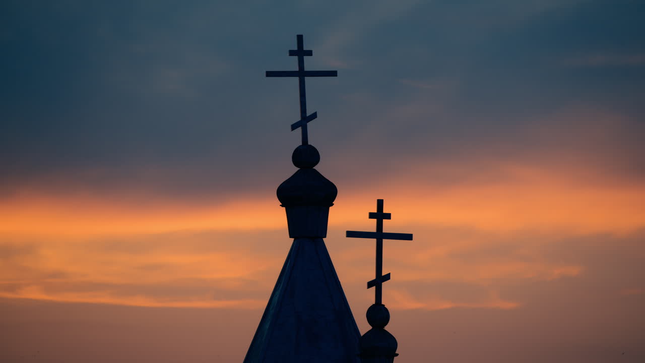 Silhouette of a church at sunset, epicsky with warm hues of orange and purple