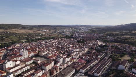 City-skyline-of-Plasencia-in-Spain,-drone-orbit-on-a-sunny-summer-day,-copypsace
