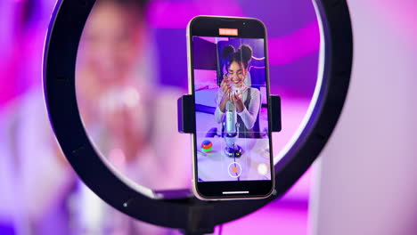 young woman recording a vlog with a smartphone and ring light