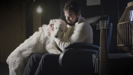 Man-in-armchair-receiving-affection-from-his-best-friend-golden-retriever