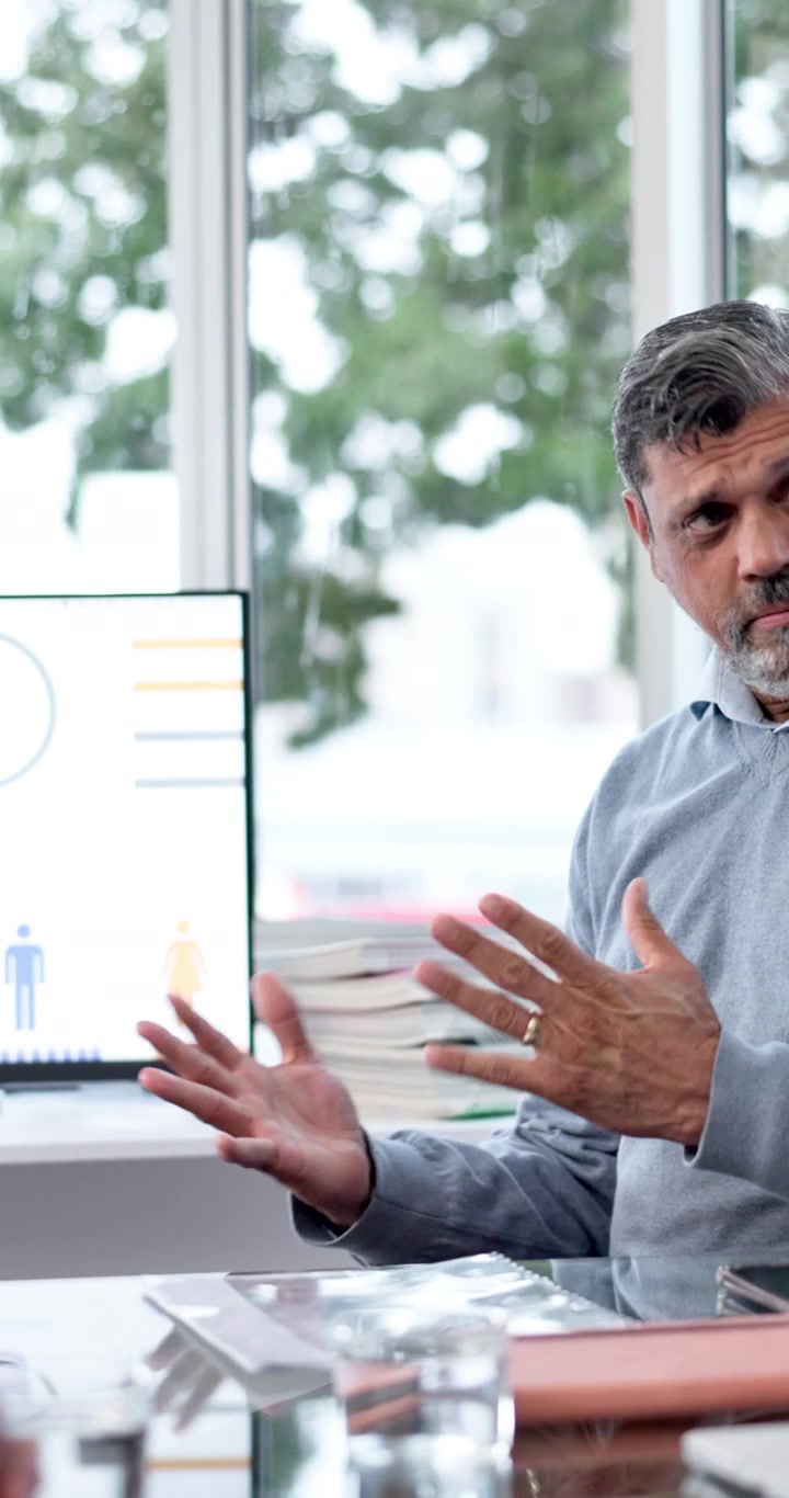 Mature Businessman Presenting Data on Computer Screen in Office