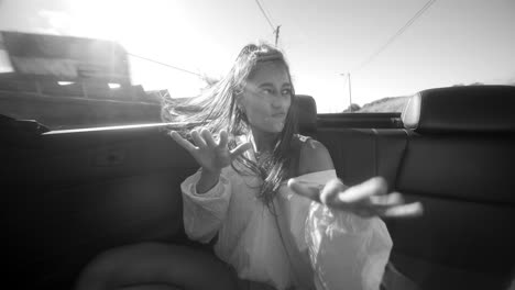 joyful woman in a convertible car, black and white