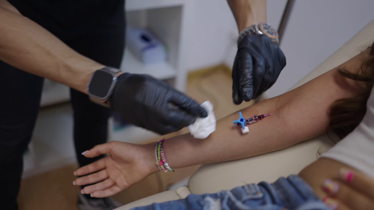 Medical professional preparing an arm for IV cannula insertion