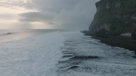 slow motion drone of sunset wave action at low tide over coral and rock reef nyang nyang beach, bali, uluwatu indonesia