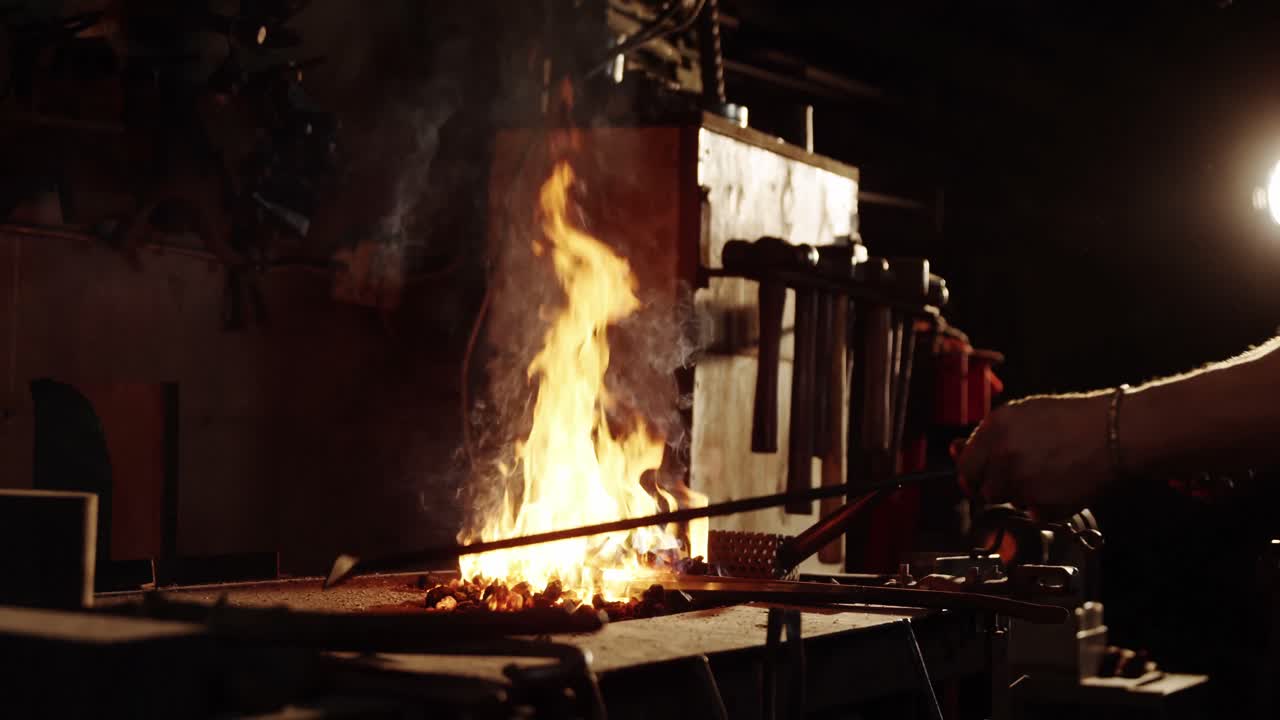 금공 이 불 에 철 막대 를 가열 하고 있다