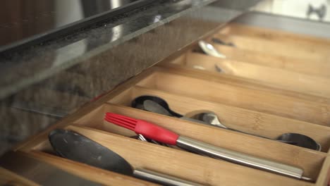 putting back utensil in a kitchen drawer