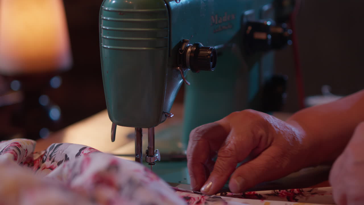 Close Up of Hands Sewing Floral Fabric on a Vintage Sewing Machine