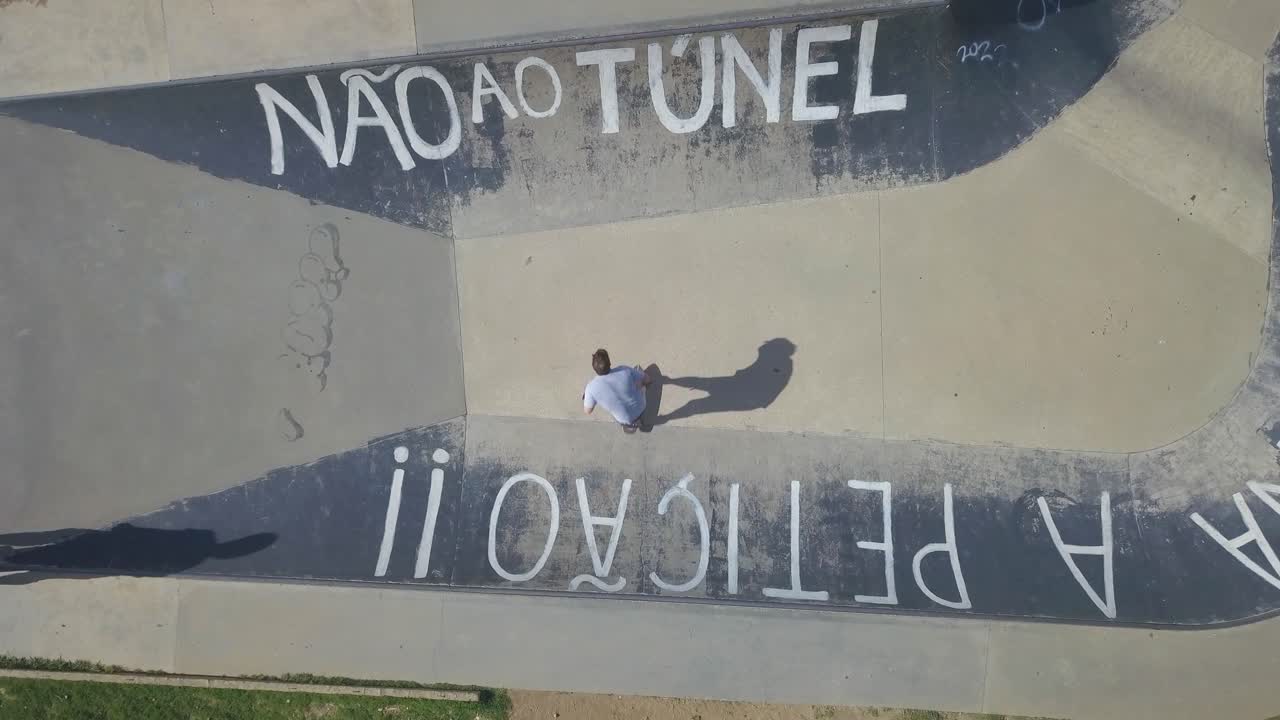 vista aérea de un patinador jugando entre los bordes de la piscina con el mensaje "no hay túnel", monopatín, modelo carver en estoril
