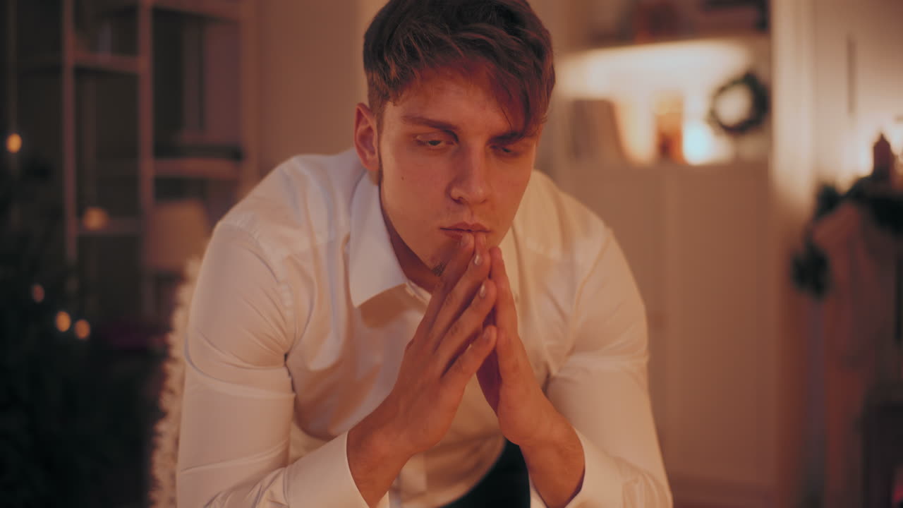 크리스마스 때 집에 앉아 있는 사려 깊은 남자