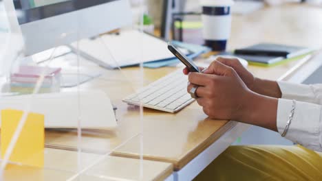 Sección-Media-De-Una-Mujer-Usando-Un-Teléfono-Inteligente-En-La-Oficina