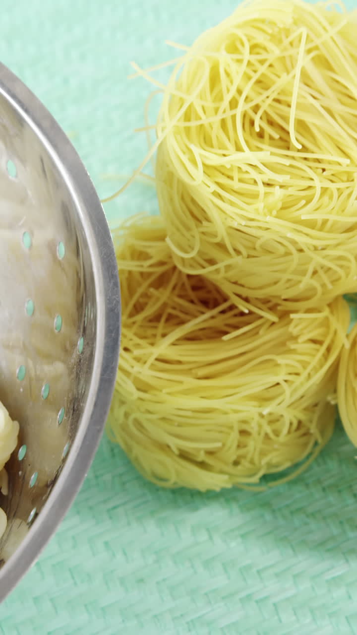 pasta hervida en colander con rollos de espagueti