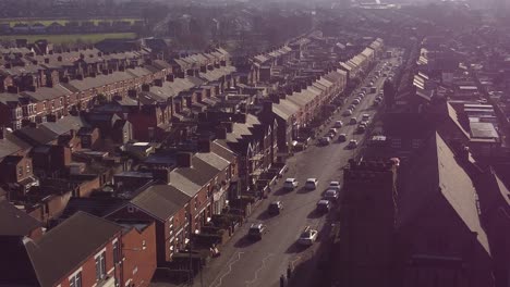 aerial rising view establishing rows of victorian terraced houses in dentons green, st helens with a long road leading towards the bustling town centre