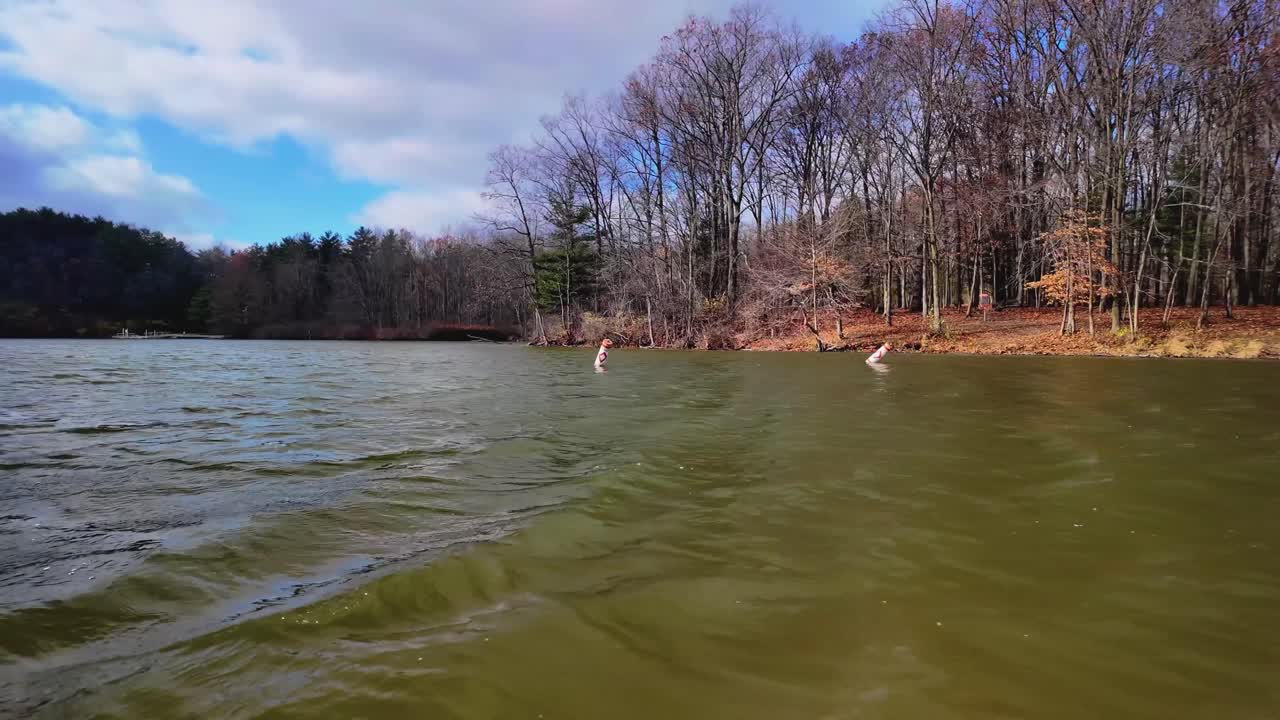 A mesmerizing slow-mo view of buoys bobbing in water, captured from a boat gliding past.