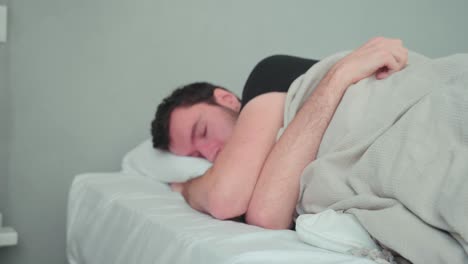 sleeping man, caucasian white with beard, young man lying in bed sleeping dreaming, uncomfortable pillow, turn over in sleep