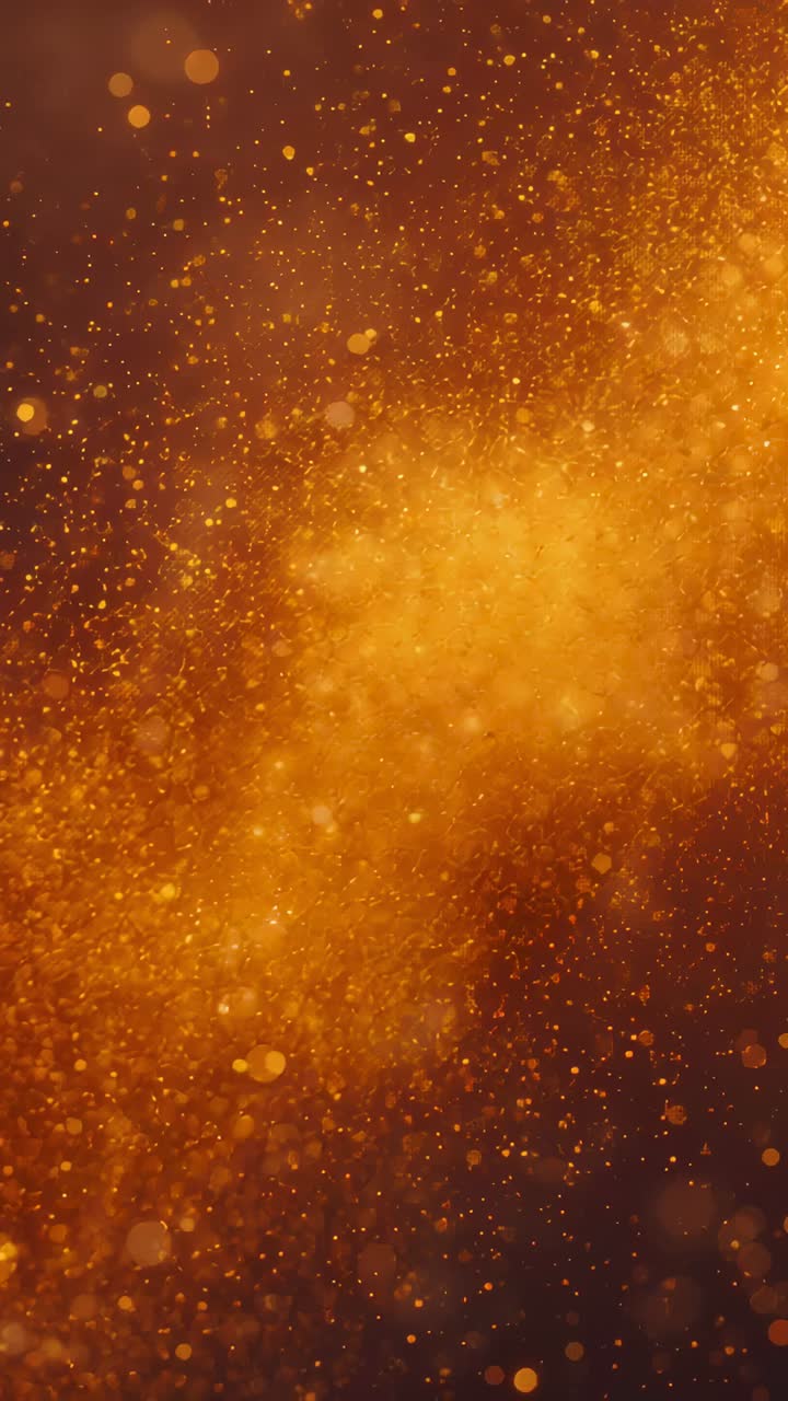 Vertical video: Glowing golden dust and bokeh reacting to warm backlight, drifting upward in studio