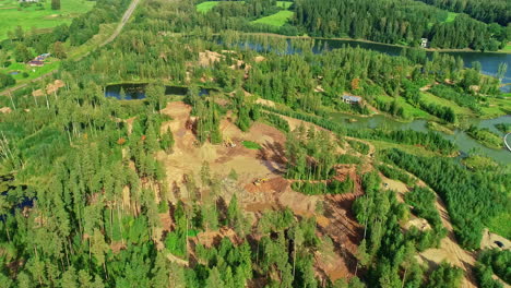 Vista-Giratoria-Por-Drones-De-Bosques-Verdes-Y-Zona-De-Estanques,-Sección-Despejada