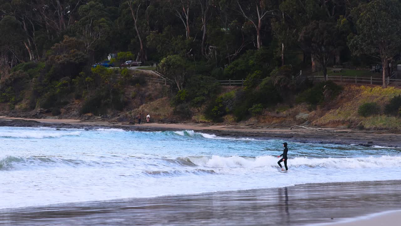 persona corriendo en la playa cerca de las olas del océano