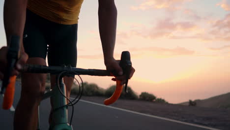 the athlete on a bike navigates a mountain serpentine in slow motion, enjoying the island's view, embodying dedication to a healthy lifestyle at sunset