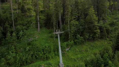 Drone-Flight-Over-Forest-With-Cable-Cars,-Panorama-Camera-Move