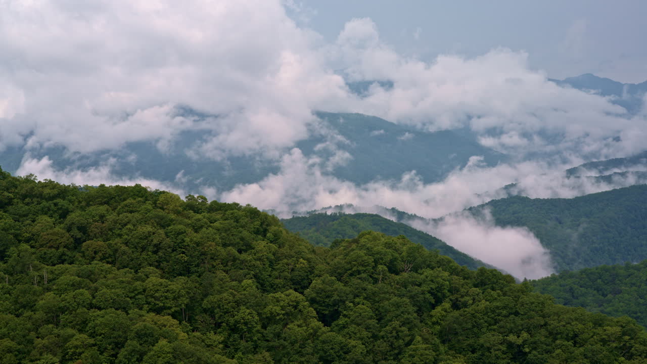 Dreamlike drone footage of mountain fog tangled with sweeping clouds