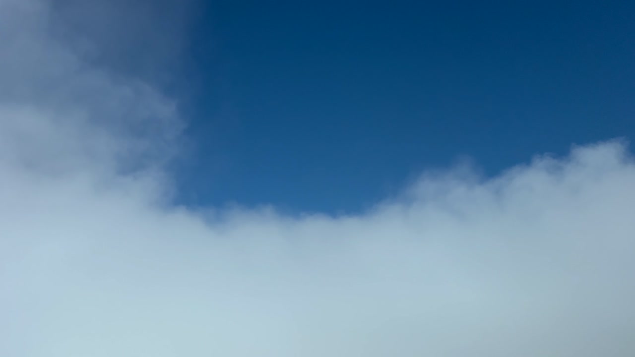 piloto pov volando a través de algunas nubes esponjosas etéreas en un día soleado con un cielo azul profundo
