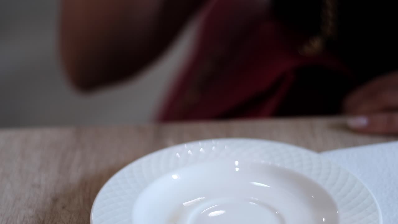 Close up of a woman drinking turmeric latte out of a white mug at a cafe