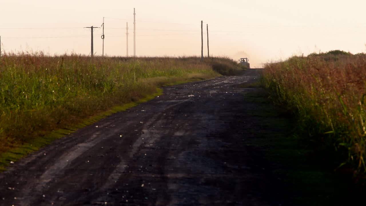 The Rough Roads In Firmat Santa Fe Argentina Surrounded With Green Grass And A Tractor Passing By During Sunset - Wide Shot