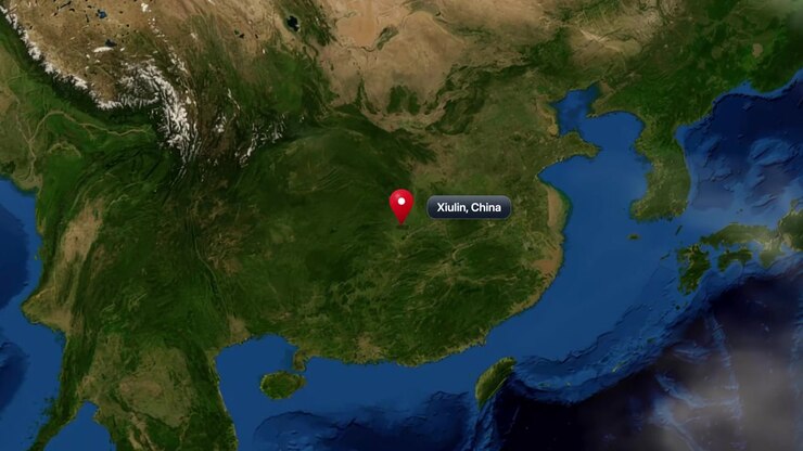 Satellite animation zooms from deep space into planet Earth, pinpointing Xiulin in China. Includes NASA public domain imagery.