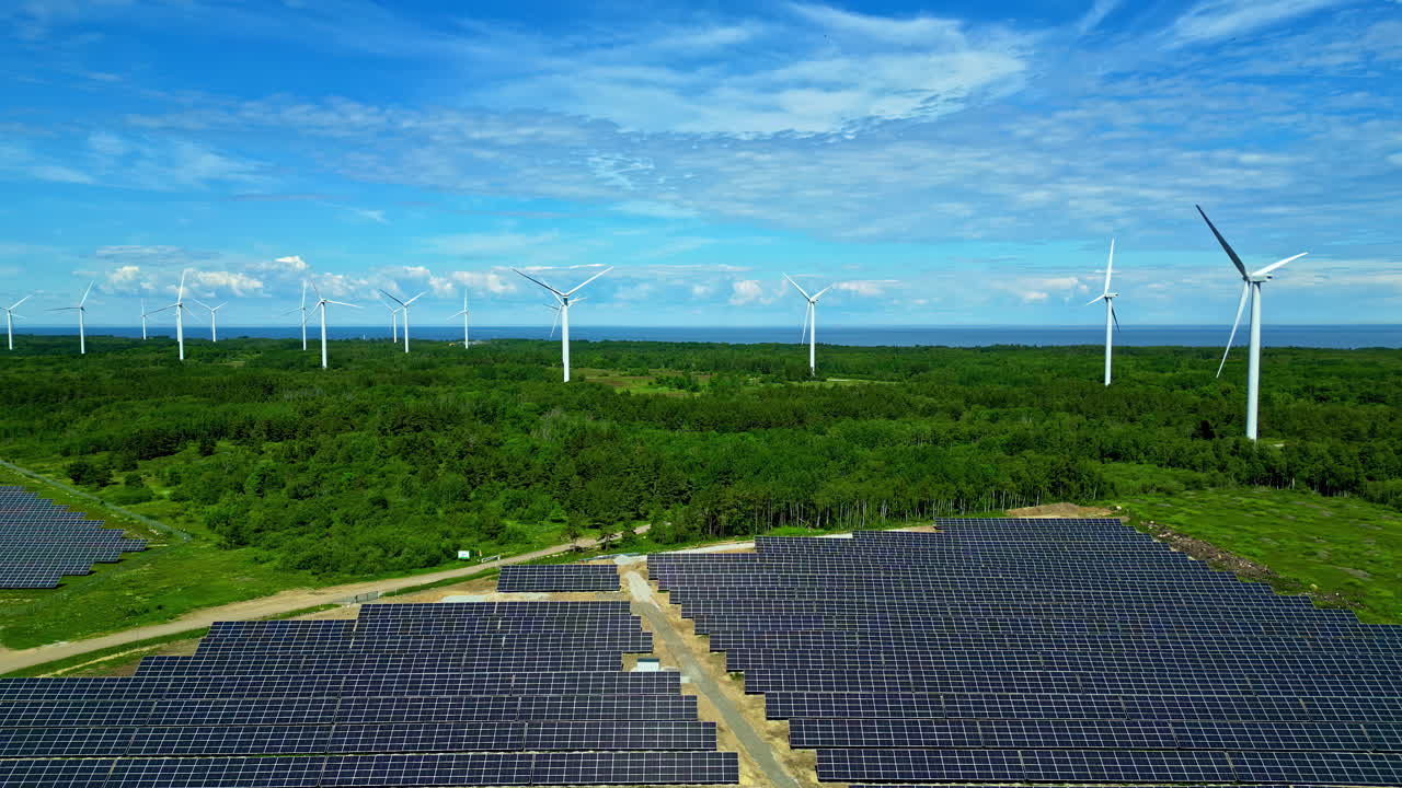 Aerial View of Solar Panels and Wind Turbines near the Ocean