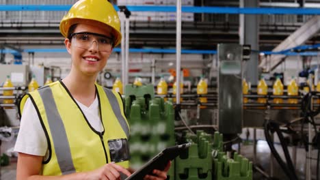 Worker-maintaining-record-on-digital-tablet-while-counting-bottles